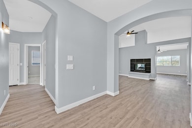 Unfurnished living room with baseboards, arched wa