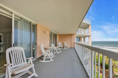 Balcony featuring view of water and beach