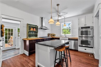 Kitchen with stainless steel appliances and center island with breakfast bar.