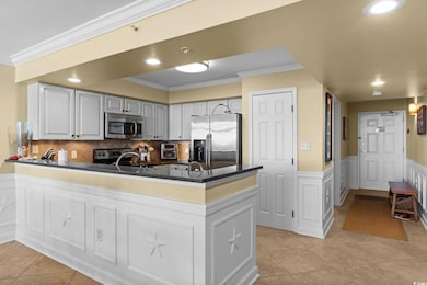 Kitchen featuring backsplash, crown molding, a wai