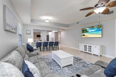 Living area with a ceiling fan and light tile patterned floors