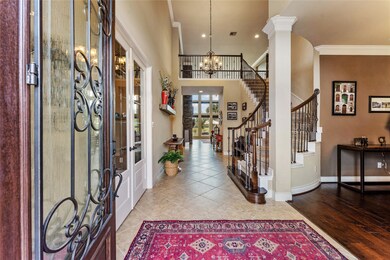 Breathtaking entrance with a spiral staircase with wrought iron spindles, tile flooring and gorgeous hard woods to the right in the dining room and to the left in the office.