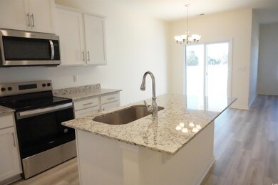 Kitchen with white cabinetry, a kitchen island wit