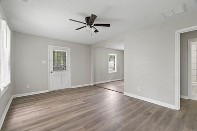 Spare room with wood finished floors, a ceiling fan, and a textured ceiling