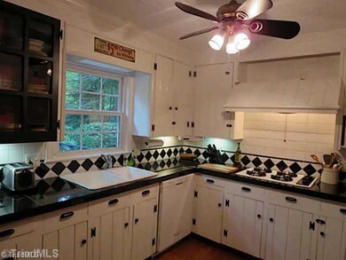 Kitchen. Lots of Character and Charm for a kitchen! Glass front cabinets, granite counters, wood floors, and ceiling fan.