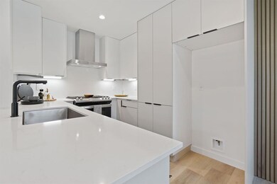 Kitchen featuring a sink, wall chimney exhaust ho