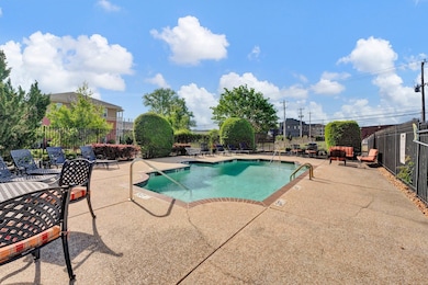 Inviting Community pool with fence and a patio area with lots of chairs with cushions.  Steps from the condo!