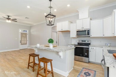 Kitchen featuring white cabinetry, pendant lightin