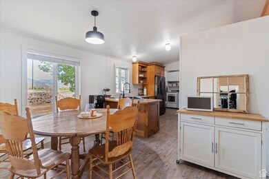 Dining area with light wood-type flooring, crown molding, and washer / clothes dryer