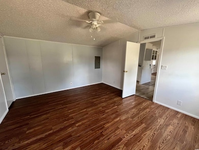 Master bedroom with wood-style floors, lofted ceil