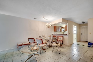 Dining room featuring a chandelier, light tile patterned floors, baseboards, and a textured ceiling
