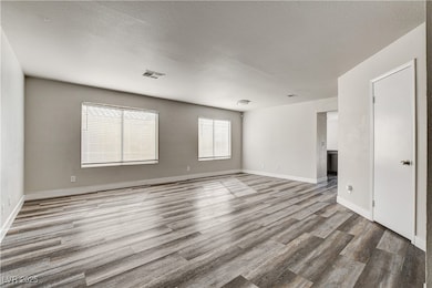 Empty room featuring a textured ceiling and light wood-style flooring