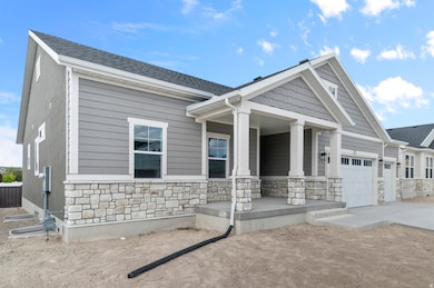 View of front of home featuring stone siding, a porch, a garage, and concrete driveway