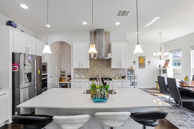 Kitchen featuring wall chimney exhaust hood, stai