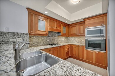 Kitchen with brown cabinets, backsplash, a sink, g