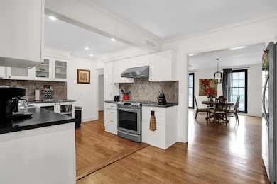Kitchen featuring white cabinetry, decorative ligh