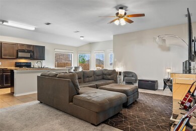 Carpeted living area featuring ceiling fan, visibl
