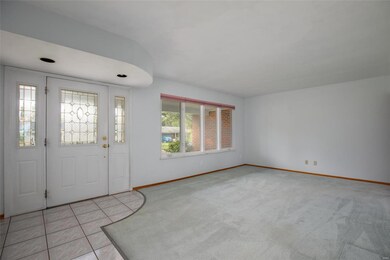 Ceramic tile entry has pretty front door with sidelights and living room with large windows