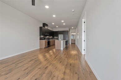 Kitchen featuring dark cabinets, open floor plan,