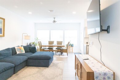 Living area featuring ceiling fan, light wood fin