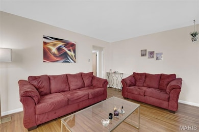 Living room with baseboards and light wood-style flooring