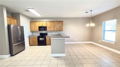 A view from the living room into the kitchen and dining area.  Did you notice the huge refrigerator and granite countertop?  Plenty of cabinet space, and pantry.