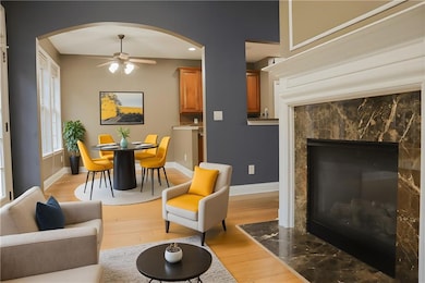 Living area with a high end fireplace, light wood-style flooring, ceiling fan, and recessed lighting