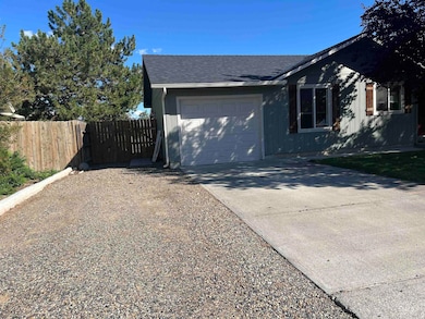 View of property exterior with driveway, a shingled roof, and a garage