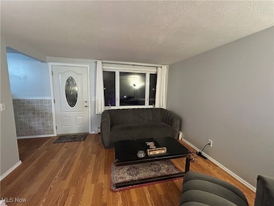 Living room with a textured ceiling and wood finished floors