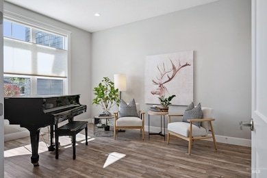 Sitting room with wood finished floors and recessed lighting