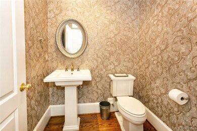 Bathroom featuring toilet, sink, and wood-type flo
