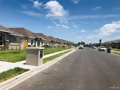 View of asphalt street with sidewalks, a residential view, curbs, and street lights