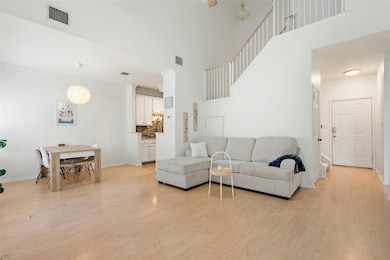 Living area featuring light wood-type flooring and a high ceiling