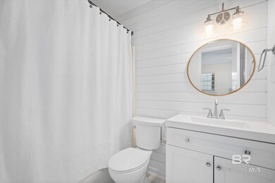 Bathroom with vanity, wooden walls, toilet, and walk in shower