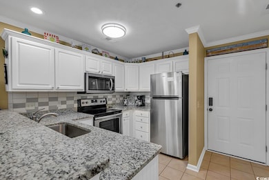 Kitchen with visible vents, a sink, appliances with stainless steel finishes, white cabinets, and light tile patterned floors