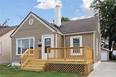 Rear view of property with a garage and a wooden d