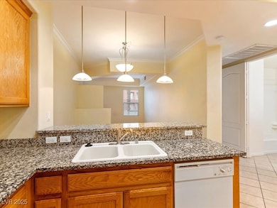 Kitchen with white dishwasher, a sink, crown moldi