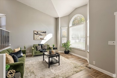 Living area with lofted ceiling and light wood-style flooring