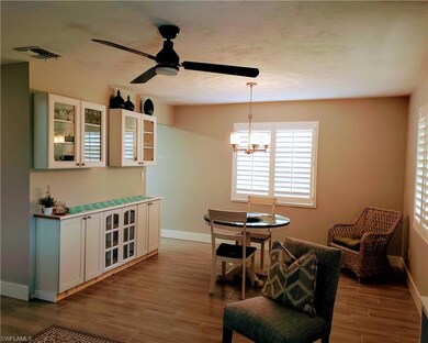 Dining room with a ceiling fan, baseboards, a chandelier, and wood finished floors