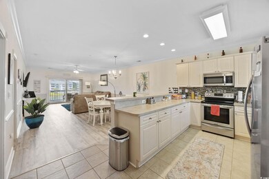 Kitchen featuring stainless steel appliances, crown molding, open floor plan, a peninsula, and light tile patterned flooring