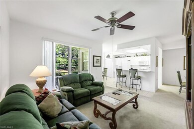 Carpeted living room featuring ceiling fan