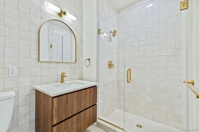 Bathroom featuring tile walls, vanity, and a stall shower