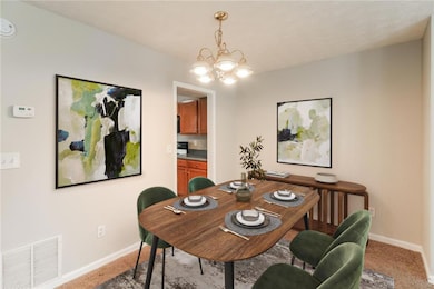Dining room with a chandelier and light carpet