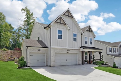 View of front of house with board and batten siding, driveway, a shingled roof, a front lawn, and a garage