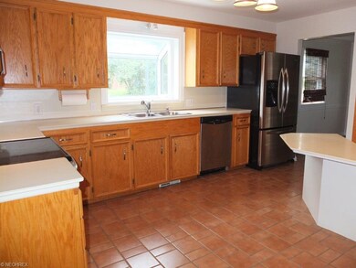 Fully applianced kitchen with tile floor.