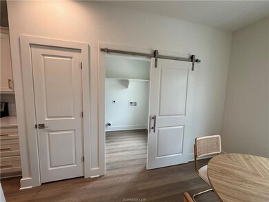 Sitting room with dark wood-type flooring and a ba