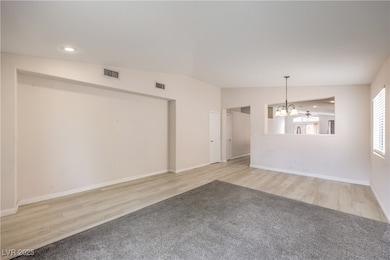 Empty room featuring a chandelier, wood finished f