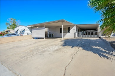 Manufactured / mobile home with concrete driveway and an attached carport