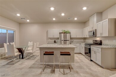 Kitchen featuring visible vents, a center island, light stone counters, and stainless steel appliances