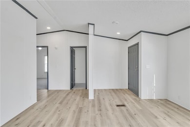 Empty room with crown molding, wood finished floor